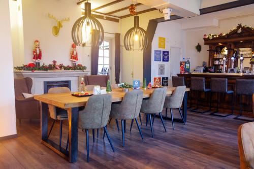 ein Esszimmer mit einem langen Tisch und Stühlen in der Unterkunft Bed & Breakfast Hotel Het Gerendal in Schin op Geul