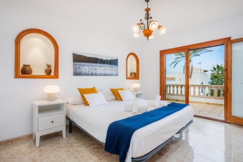 a bedroom with a large bed and a balcony at Ca n' Auba in Colonia de Sant Pere