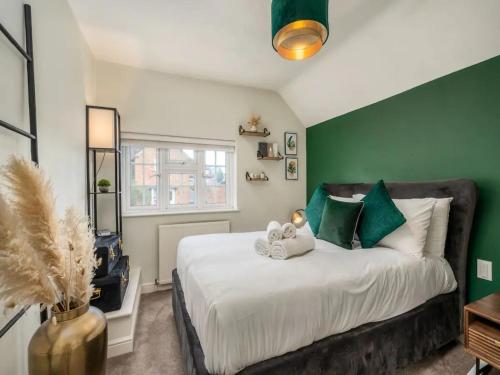 um quarto com uma cama grande e paredes verdes em Pass the Keys Stylish Modern 3 bed house with Parking em Rickmansworth