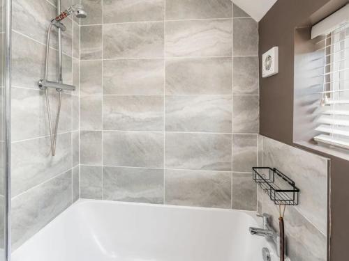 a bathroom with a shower and a bath tub at Pass the Keys Stylish Modern 3 bed house with Parking in Rickmansworth