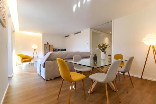 a living room with a table and yellow chairs at Viana Urban Glamour in Viana do Castelo