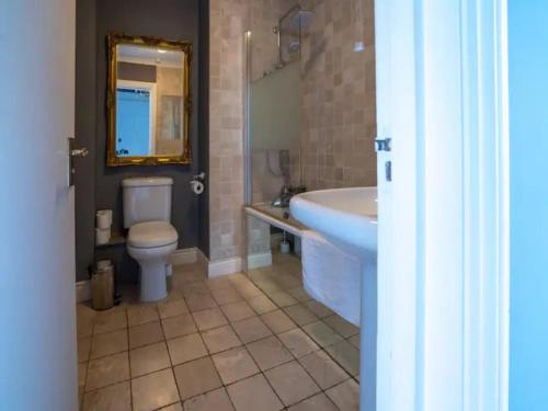 a bathroom with a sink and a toilet and a mirror at Pass the Keys Lovely bright and central apartment in Cheltenham in Cheltenham