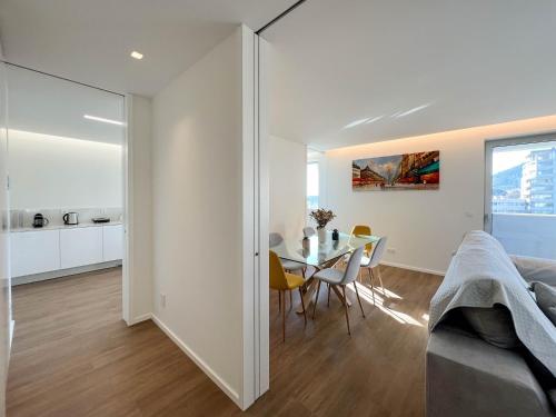 a white apartment with a dining room and a table at Viana Urban Glamour in Viana do Castelo