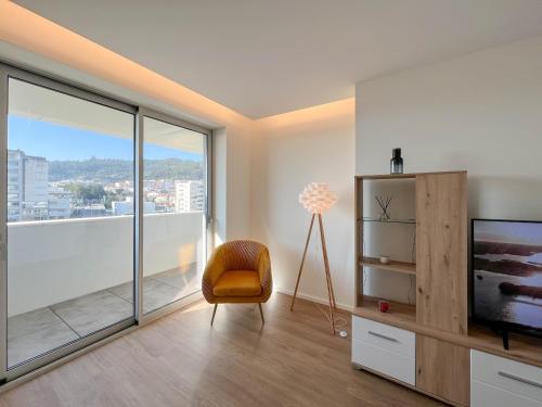 a living room with a television and a chair at Viana Urban Glamour in Viana do Castelo