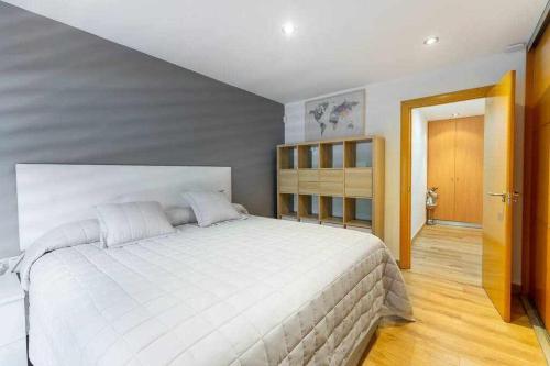 a bedroom with a large white bed in it at Apto moderno 1ª linea de playa in Benicàssim