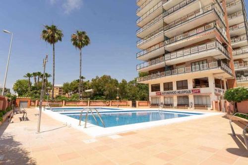 a swimming pool in front of a building at Apto moderno 1ª linea de playa in Benicàssim