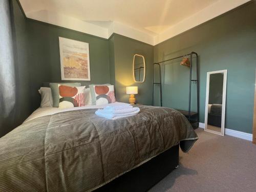 una camera da letto con un grande letto con pareti verdi di Recently Refurbished 3 Bedroom Home with Parking - Perfect for Longstays - Sleeps 8 a Chester