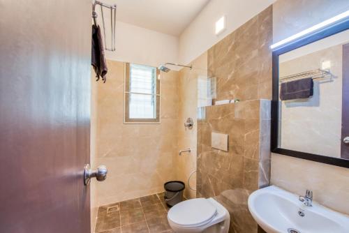 a bathroom with a shower and a toilet and a sink at Iyla Apart Hotel in Puducherry