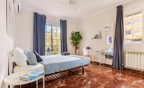 a bedroom with a bed and a table and a window at Casa la Fontana in Granada