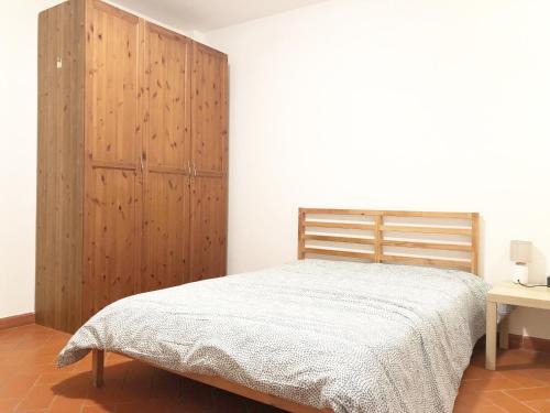 a bedroom with a bed and a wooden cabinet at Turfrose di San Rossore a Pisa by Zoom In Earth in Pisa