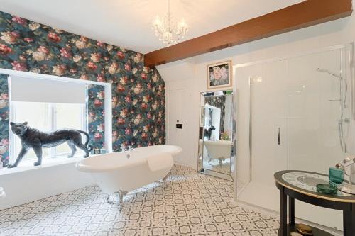 a bathroom with a tub and a dog in the window at Killorglin Irish Pub With Hot Tub That Sleeps 19 in Killorglin