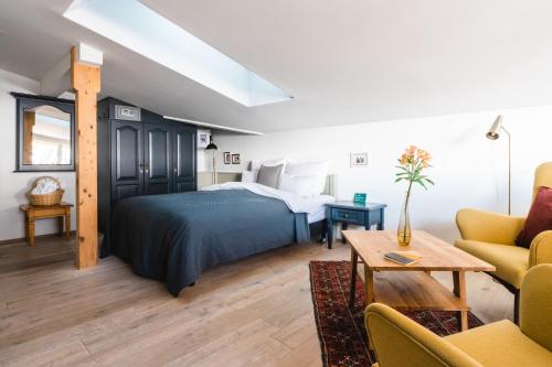 1 dormitorio con 1 cama y sala de estar en HENRI Country House Seefeld, en Seefeld in Tirol
