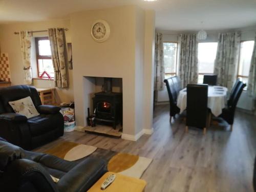 a living room with a couch and a table and a fireplace at The lake house in Gweedore