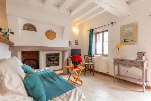 ein Wohnzimmer mit einem Kamin und einem Tisch in der Unterkunft La Nigaudière - Les Bruyères in Lassay-sur-Croisne