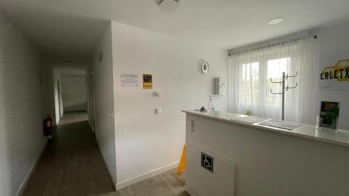 a white room with a counter and a window at Erletxe Aterpea in Lezo