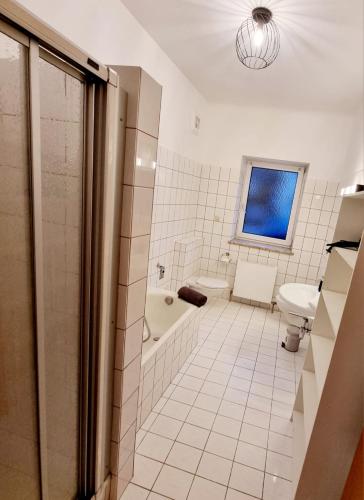 a bathroom with a tub and a toilet and a sink at Bergblick Appartements in Bad Gastein