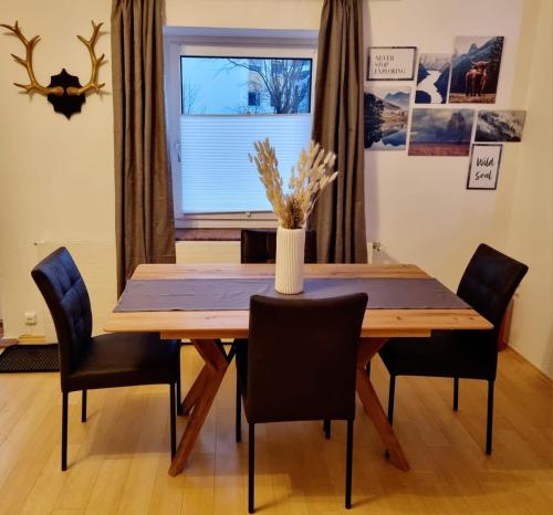 a dining room table with chairs and a vase on it at Bergblick Appartements in Bad Gastein