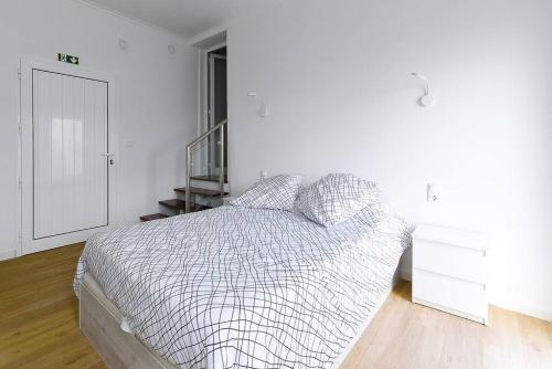 ein weißes Schlafzimmer mit einem Bett und einer Treppe in der Unterkunft Casa do Mar in Funchal