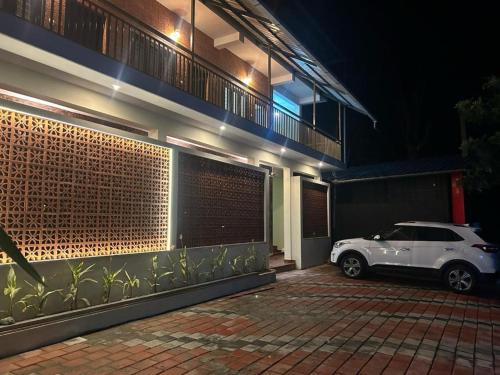 a white car parked outside of a building at night at Athirappilly Inn in Athirappilly