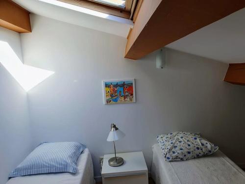 une chambre avec un lit et une table avec une lampe dans l'établissement Appartement indépendant en rdc dans propriété, à La Madrague