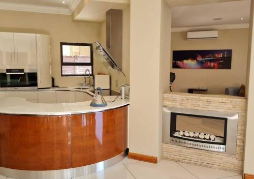 a kitchen with a fireplace and a sink in a room at 10 Pecanwood Dr 4 Bedroom Beauty in Hartbeespoort