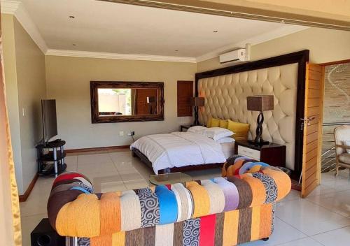 duża sypialnia z łóżkiem i kanapą w obiekcie 10 Pecanwood Dr 4 Bedroom Beauty w mieście Hartbeespoort