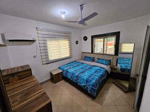 a bedroom with a bed and a ceiling fan at Private-room with washroom in spintex, Accra in Accra