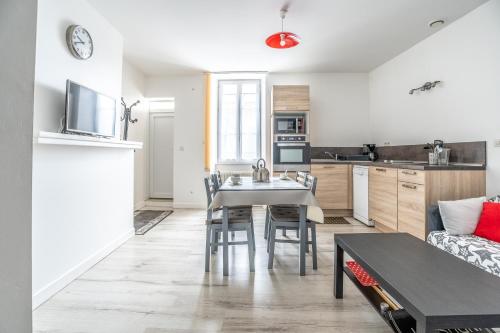 une cuisine et un salon avec une table et des chaises dans l'établissement Coeur de Ville 1 & 2, à Jonzac