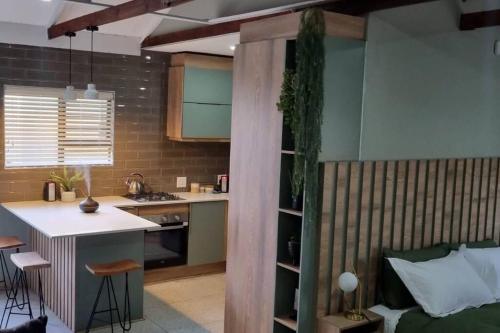 eine Küche mit einem Bett und einem Schreibtisch in einem Zimmer in der Unterkunft Leipoldt Self-Catering Apartment in Secunda