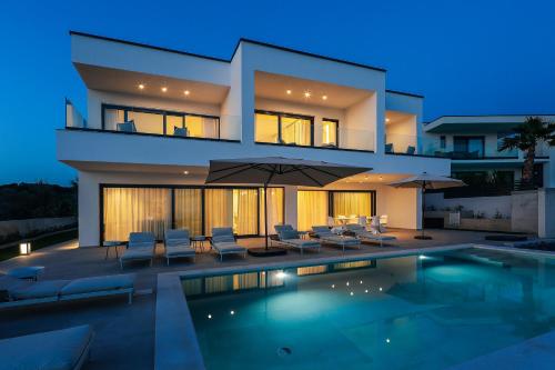 a house with a swimming pool at night at Luxury Villa 360 - private heated pool in Novalja