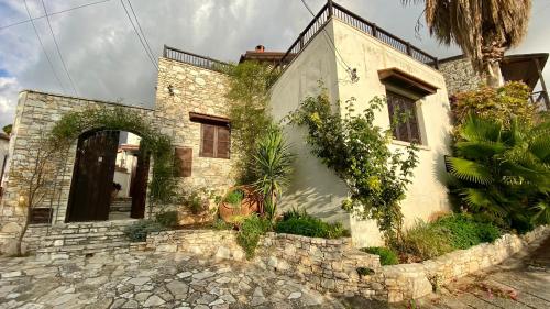 an old stone house with a stone wall at Juliet Suite by TrulyCyprus in Doros