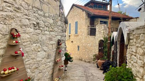 an alley with stone buildings and fruits and vegetables at Juliet Suite by TrulyCyprus in Doros
