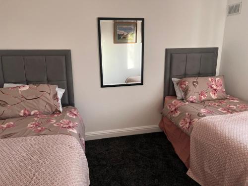 sypialnia z 2 łóżkami i lustrem na ścianie w obiekcie The Genesis one w Manchesterze