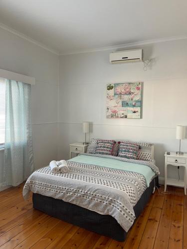 a white bedroom with a bed with pillows at Apartment 1 on Oxide in Broken Hill