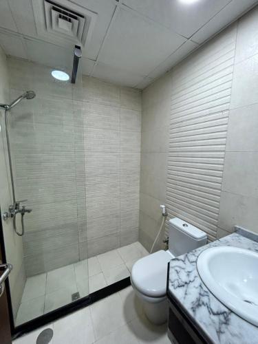 a bathroom with a shower and a toilet and a sink at Homecation in Dubai