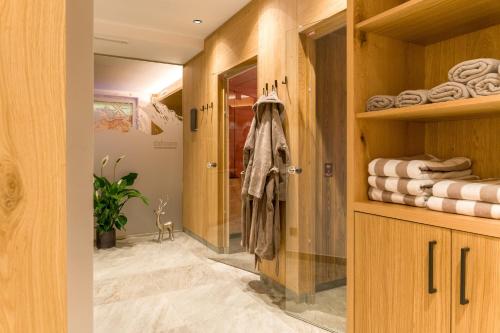 霍爾茨高的住宿－菲莉斯克羅斯哈蒙妮旅館，一间带木制橱柜和步入式衣柜的浴室