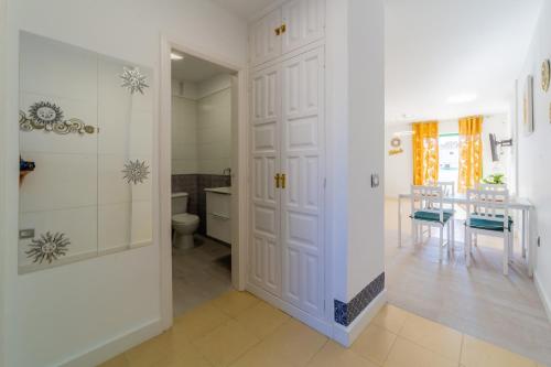 a bathroom with a white door and a table at Soleado en Alondras Park in Costa Del Silencio