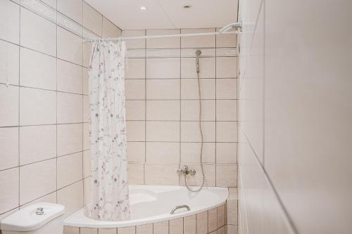 y baño con bañera, aseo y ducha. en Jenny Apartments en Zakynthos