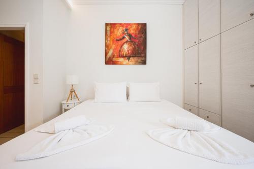 a white bedroom with a white bed with two pillows at Jenny Apartments in Zakynthos Town