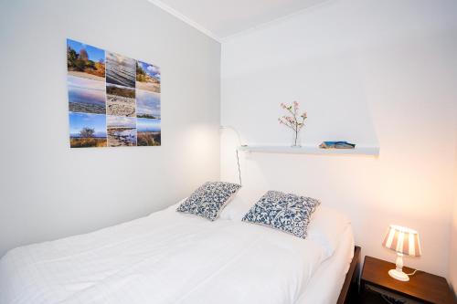 um quarto com uma cama branca e um quadro na parede em Fewo Seerobbe A-6 2, mit Meerblick em Sierksdorf