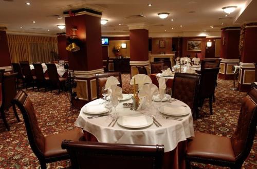 a restaurant with tables and chairs with white table settings at Apartment Snezhanka in Pamporovo