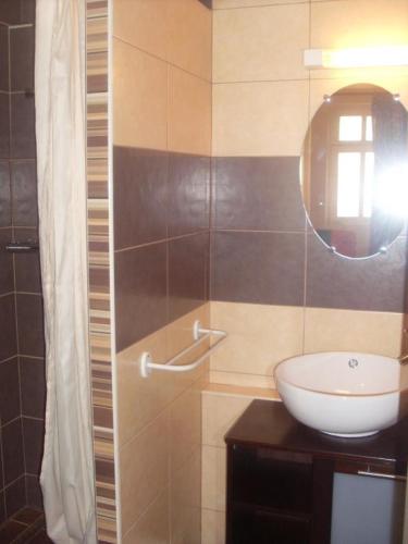 une salle de bain avec un lavabo et un miroir dans l'établissement Le village, à Polisy