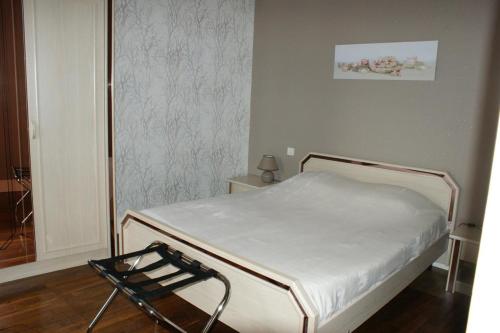 a small bedroom with a bed and a chair at Le village in Polisy