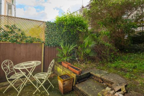 a backyard with a table and chairs and a fire pit at Idyllic Clifton Hideaway - Stunning Garden Flat in Bristol