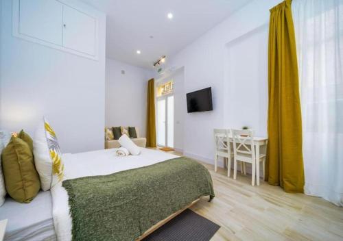 a bedroom with a bed and a table and a television at (J6) Loft 4 personas Céntrico Madrid in Madrid