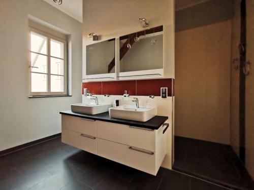 uma casa de banho com 2 lavatórios e um espelho em Komfortables Apartment im Zentrum Erfurts em Erfurt