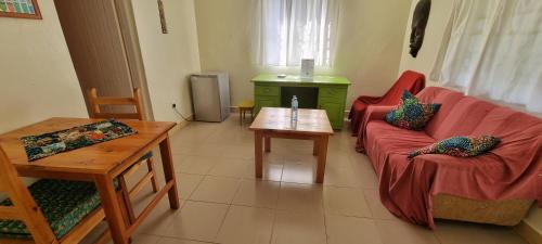 a living room with a red couch and a table at Mutolere Coffee Pot Guest Houses in Kisoro