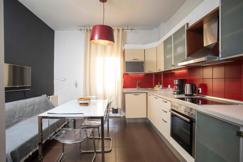 a kitchen with a table and a red wall at SERAFINA HOME in Thessaloniki