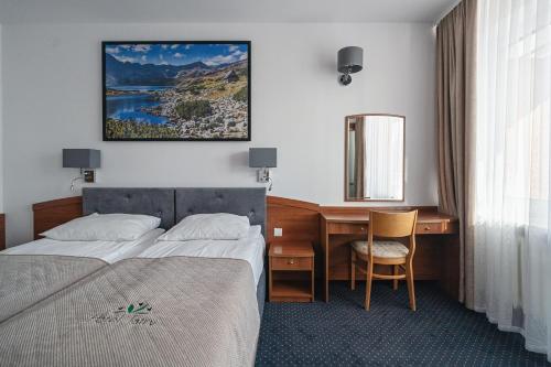 um quarto de hotel com uma cama e uma secretária em Zespół Tatry - Hotel Tatry i Budynek Turystyczny em Murzasichle