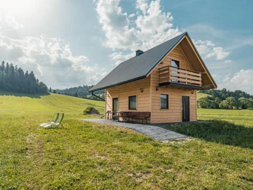 a small wooden house in a field with a bench at Spiska Chatka in Kacwin